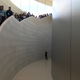 A parade of journalists march down the giant marble staircase, as an Apple employee waits to makes sure no one goes the wrong way.